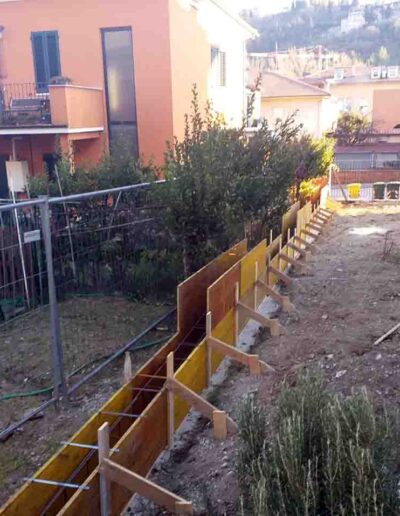 Realizzazione nuovo muro di confine con installazione dei casseri necessari prima del getto - San Severino